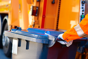 Symbolbild f&uuml;r Abfallentsorgung mit Entsorgungsfahrzeug und Abfalltonne