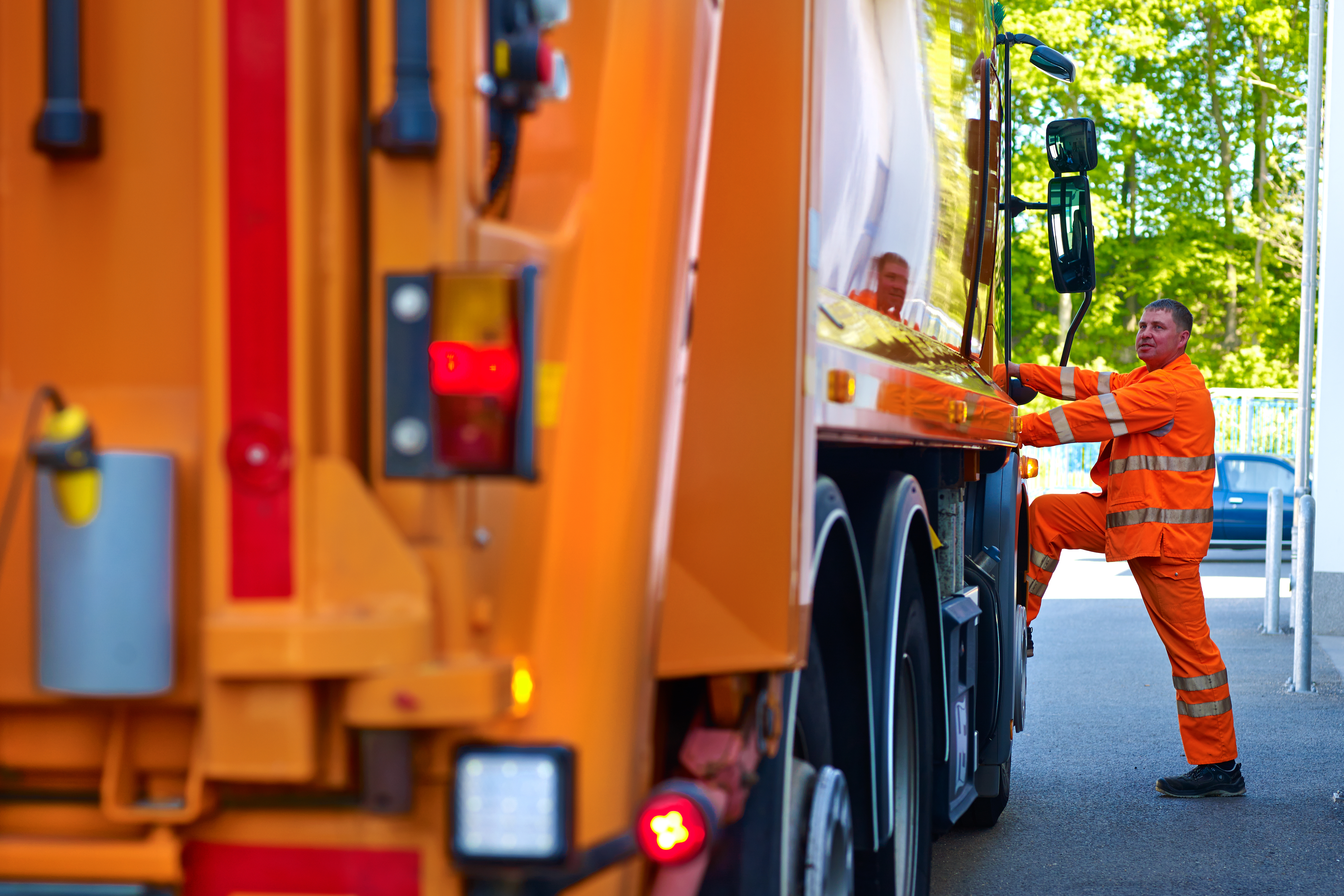 Foto M&uuml;llwerker steigt in Entsorgungsfahrzeug