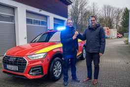 Kreisbrandmeister Alexander L&ouml;chel nimmt den Schl&uuml;ssel des neuen Kommandowagens freudig vom Beigeordneten Mario M&uuml;ller entgegen