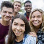 Gruppe junger Frauen und M&auml;nner schauen den Betrachter freundlich an