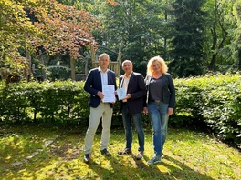 Auf diesem Spielplatz soll eine barrierefreie Picknick-Ecke entstehen. Landrat Carsten Michaelis (links im Bild) brachte den Zuwendungsbescheid pers&ouml;nlich vorbei.