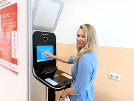 Eine Frau beim Bedienen des Selbstbedienungsterminals f&uuml;r die Anfertigung von Fotos f&uuml;r den F&uuml;hrerschein