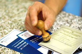 ein F&uuml;hrerschein wird von Hand abgestempelt