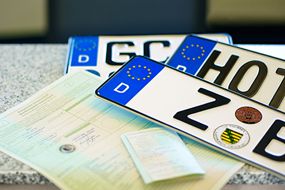 drei verschiedene Nummernschilder und die Fahrzeugbriefe I und II