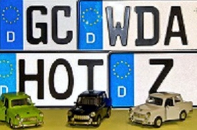 vier Kennzeichenschilder und drei Modellautos