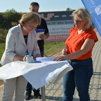 Im Bild links Frau Beres, 1. Stellvertreterin des Oberb&uuml;rgermeisters der Gro&szlig;en Kreisstadt Crimmitschau, beim Unterzeichnen der &Uuml;bergabeurkunde, rechts im Bild Frau Leberecht und im Hintergrund Herr Stangl vom Amt f&uuml;r L&auml;ndliche Entwicklung und Vermessung 